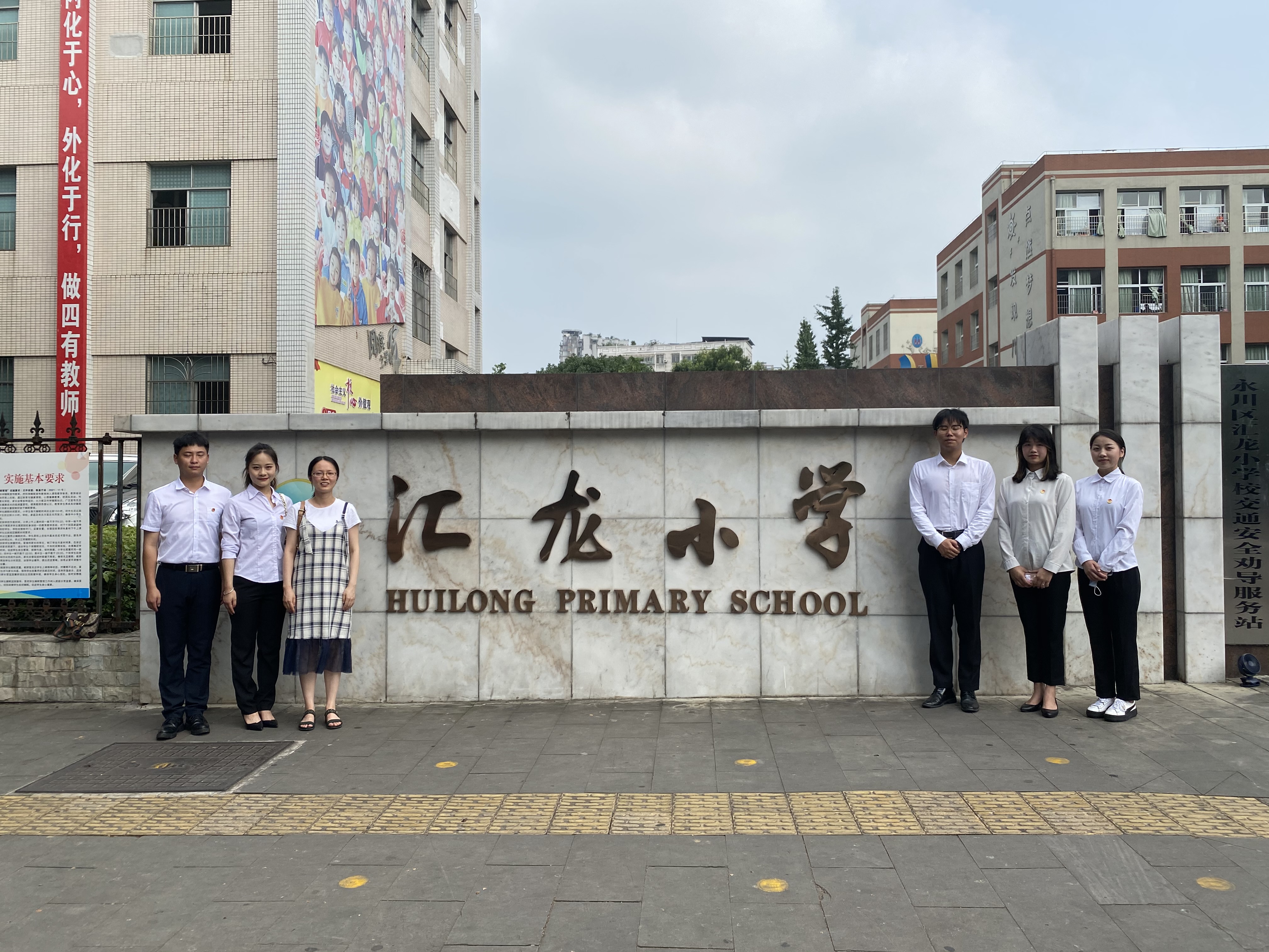 带队老师和五名同学在小学门口合影留念.JPG